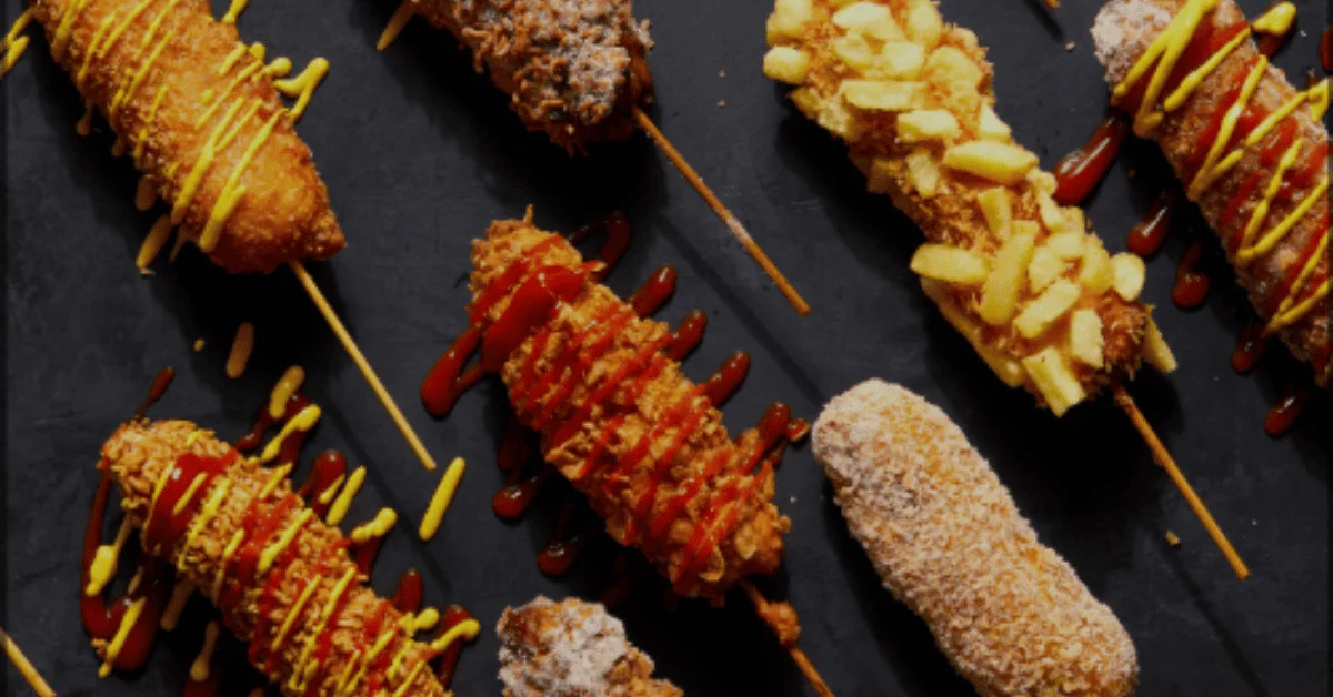 Korean Corn Dog varieties with different toppings like ketchup, mustard, sugar, and potato fries on a black background.